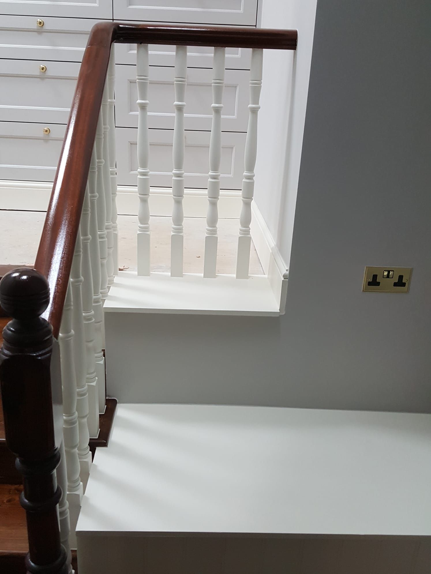 A staircase with a wooden railing and white steps