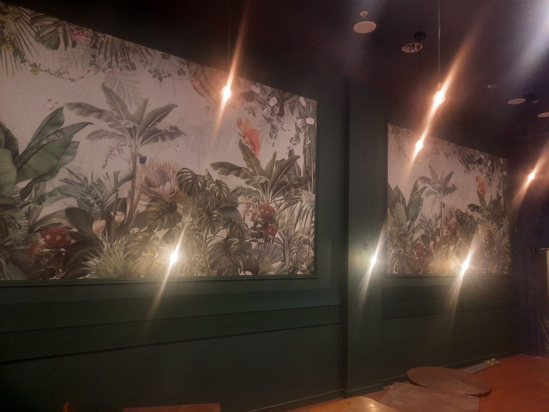 A room with a mural on the wall and lights on the ceiling.