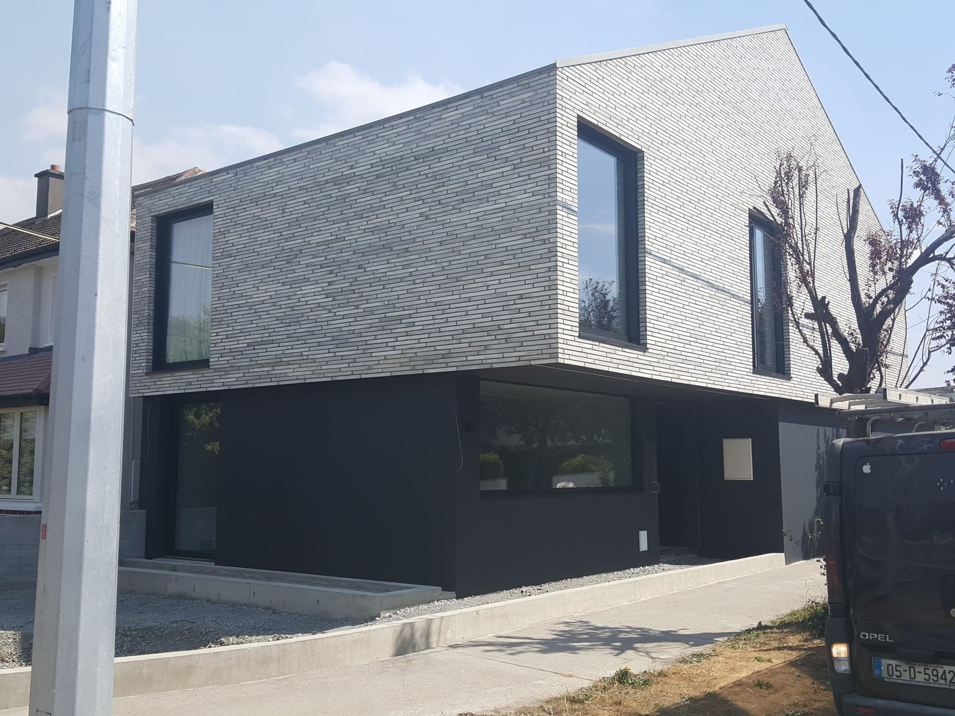 A black and white house with a lot of windows is being built.