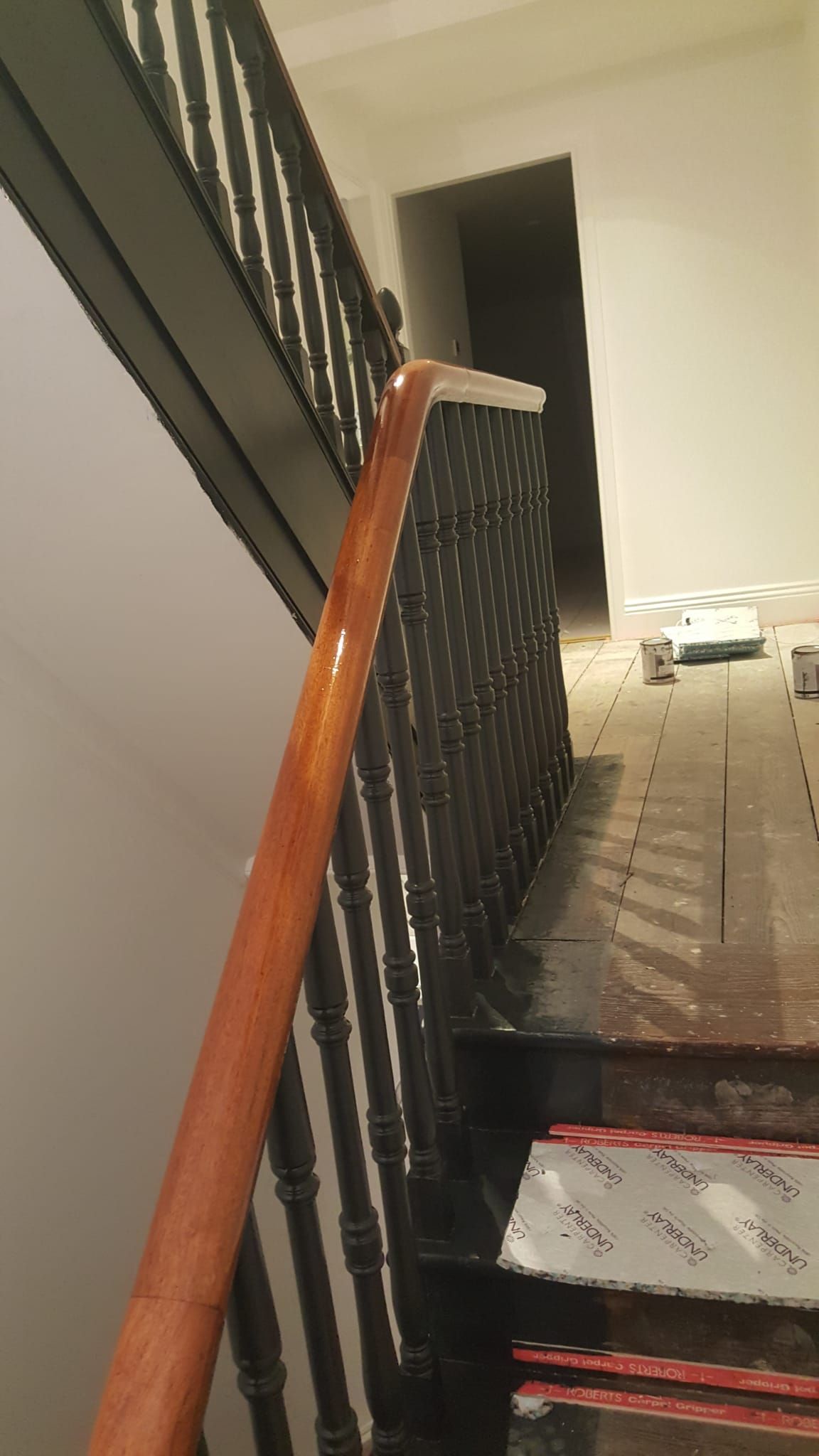 A close up of a wooden railing on a set of stairs.