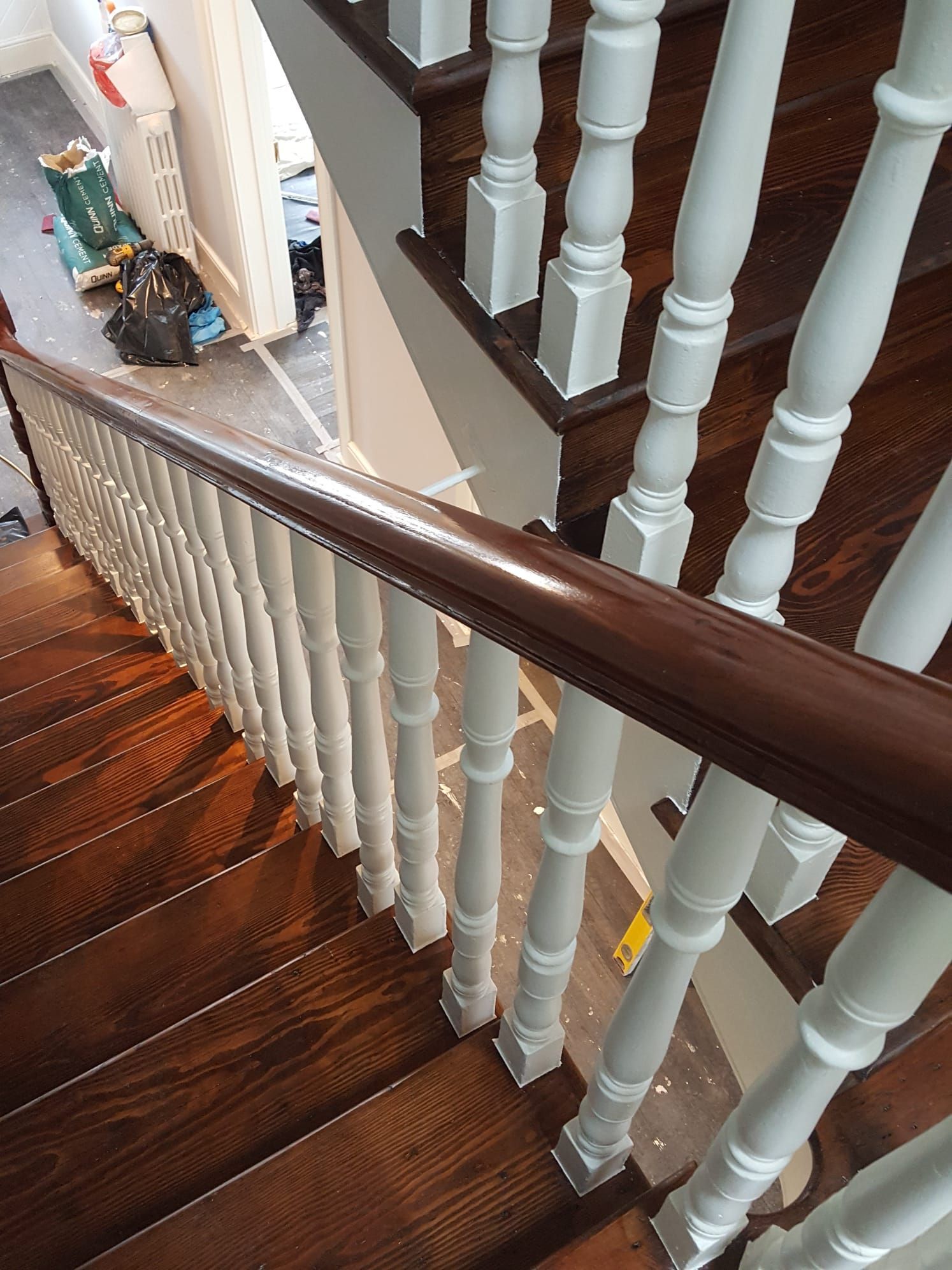 A close up of a wooden staircase with white railings