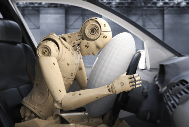 Picture of a test dummy in a crashed car with the airbag deployed. 