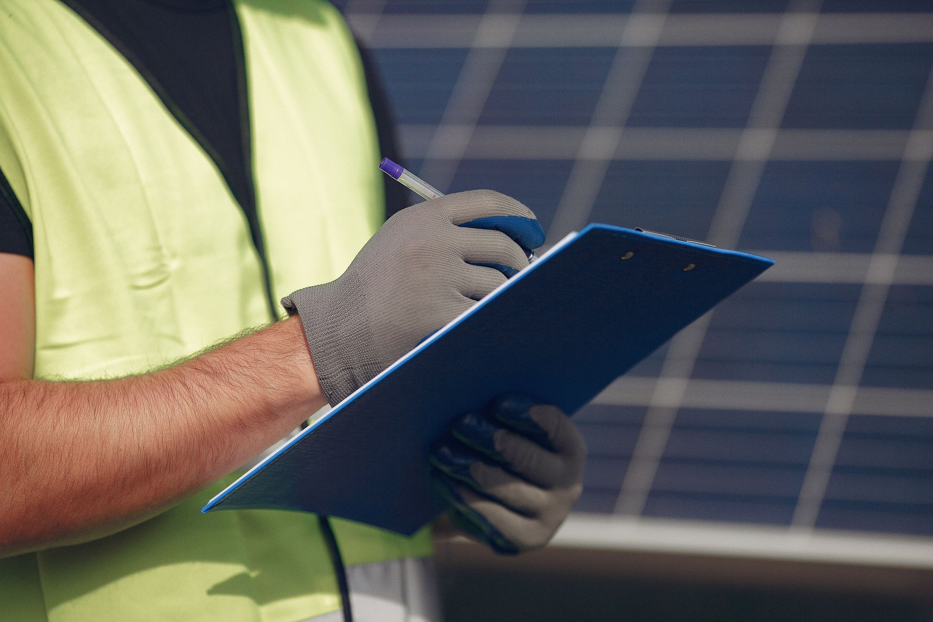 Engenheiro a escrever notas com painéis solares no fundo
