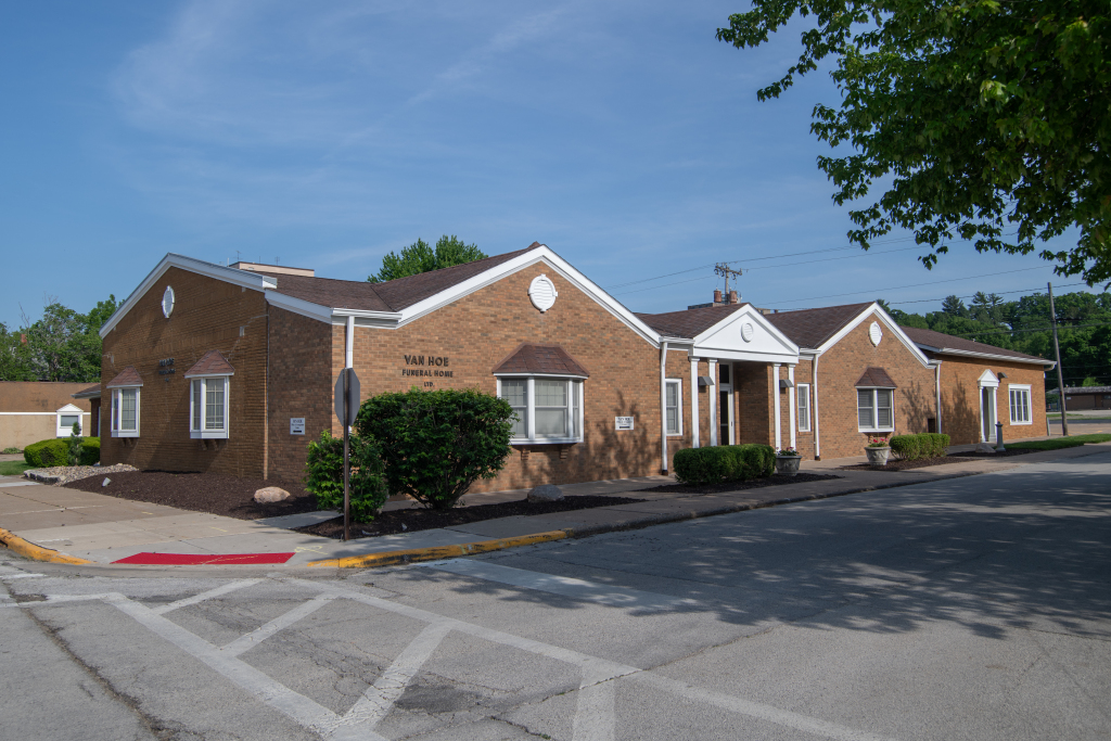 Low brick building with white trim, a sign that reads