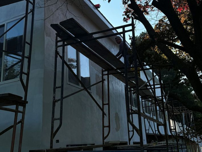 A house is being painted with scaffolding around it