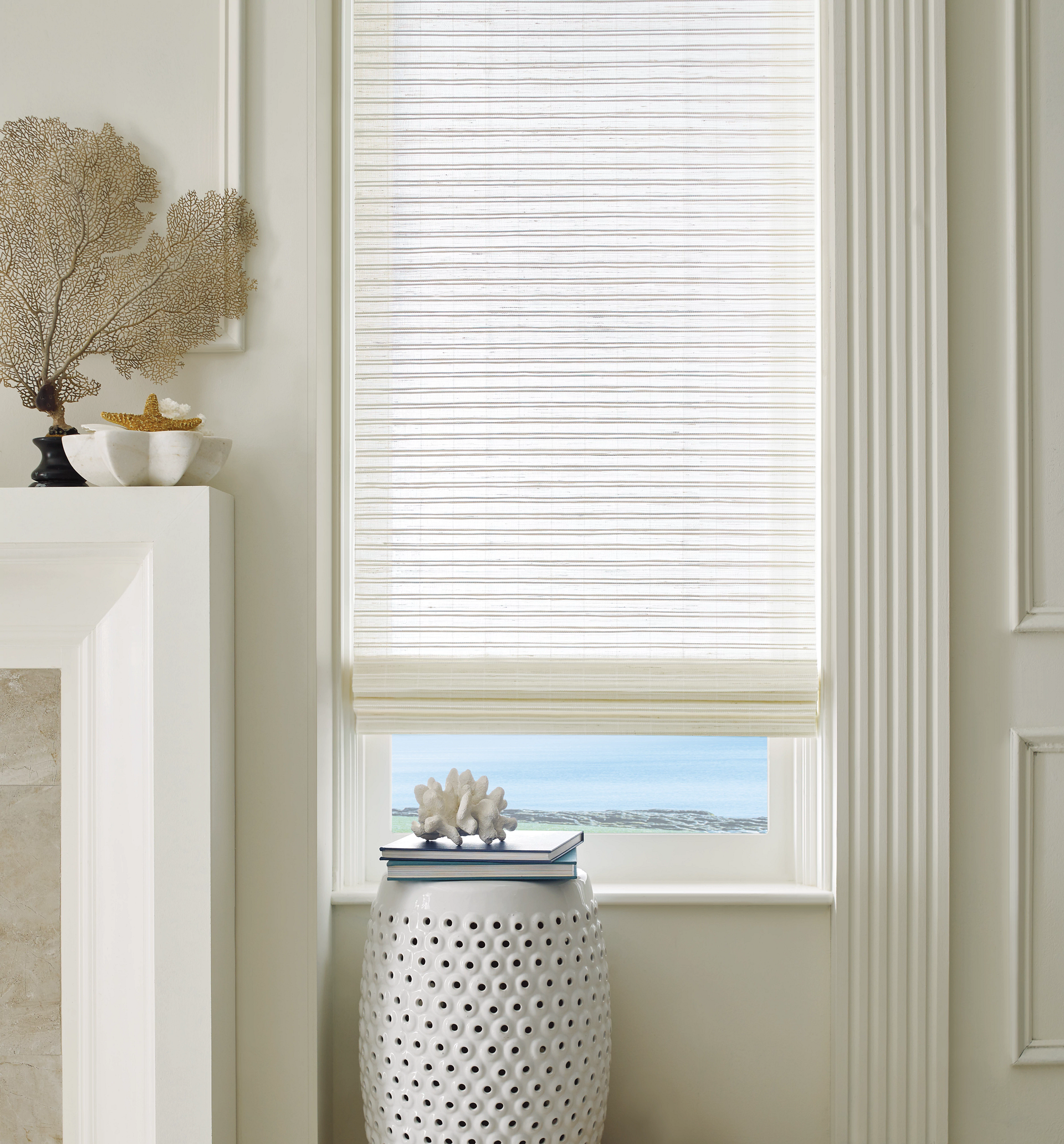 Bright room with a white woven stool under a window and light beige blinds.