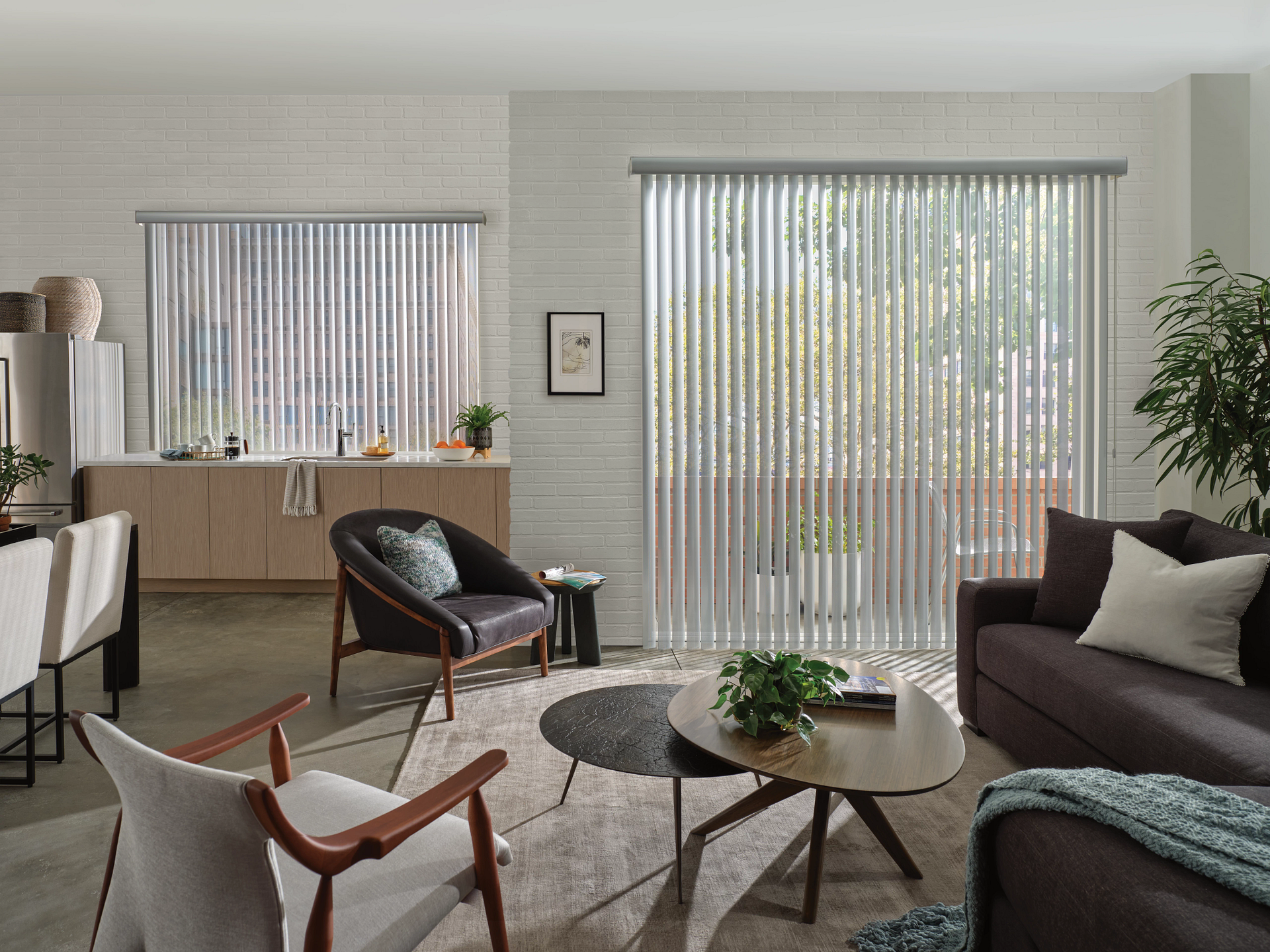 Modern living room with vertical blinds, gray sofa, wood chairs, and round coffee tables by large windows