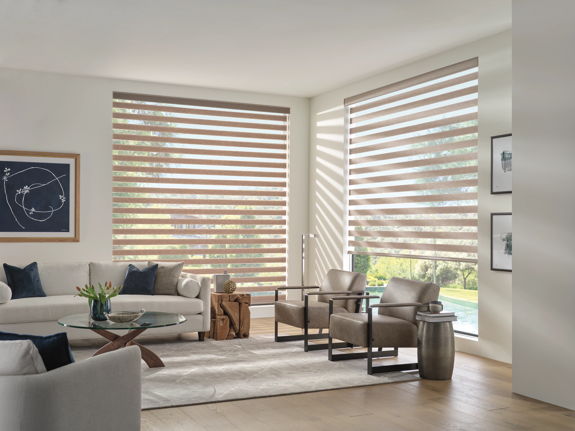Bright modern living room with gray sofas, striped blinds, and neutral decor by large windows
