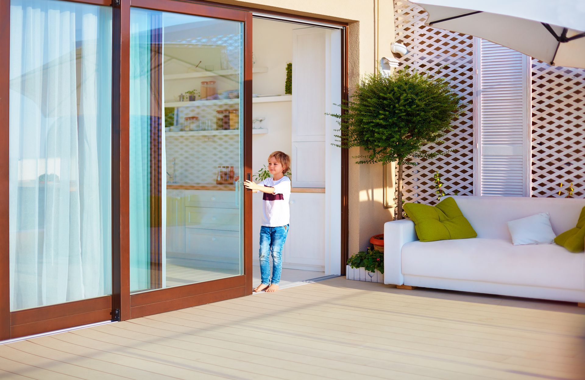 A child pulling a sliding glass door closed