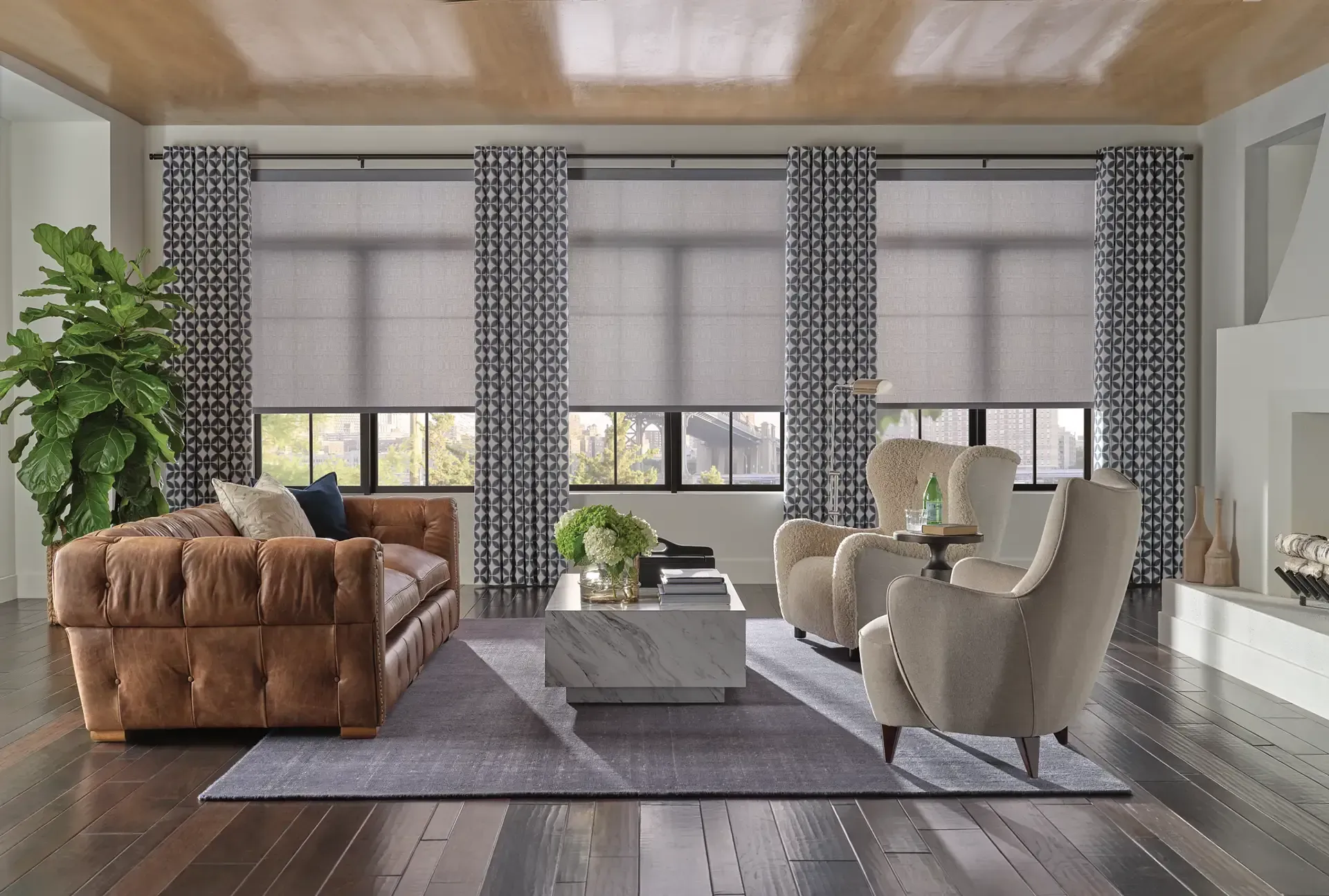 Bright modern living room with large windows, gray sofa and chairs, brown leather couch, and coffee table