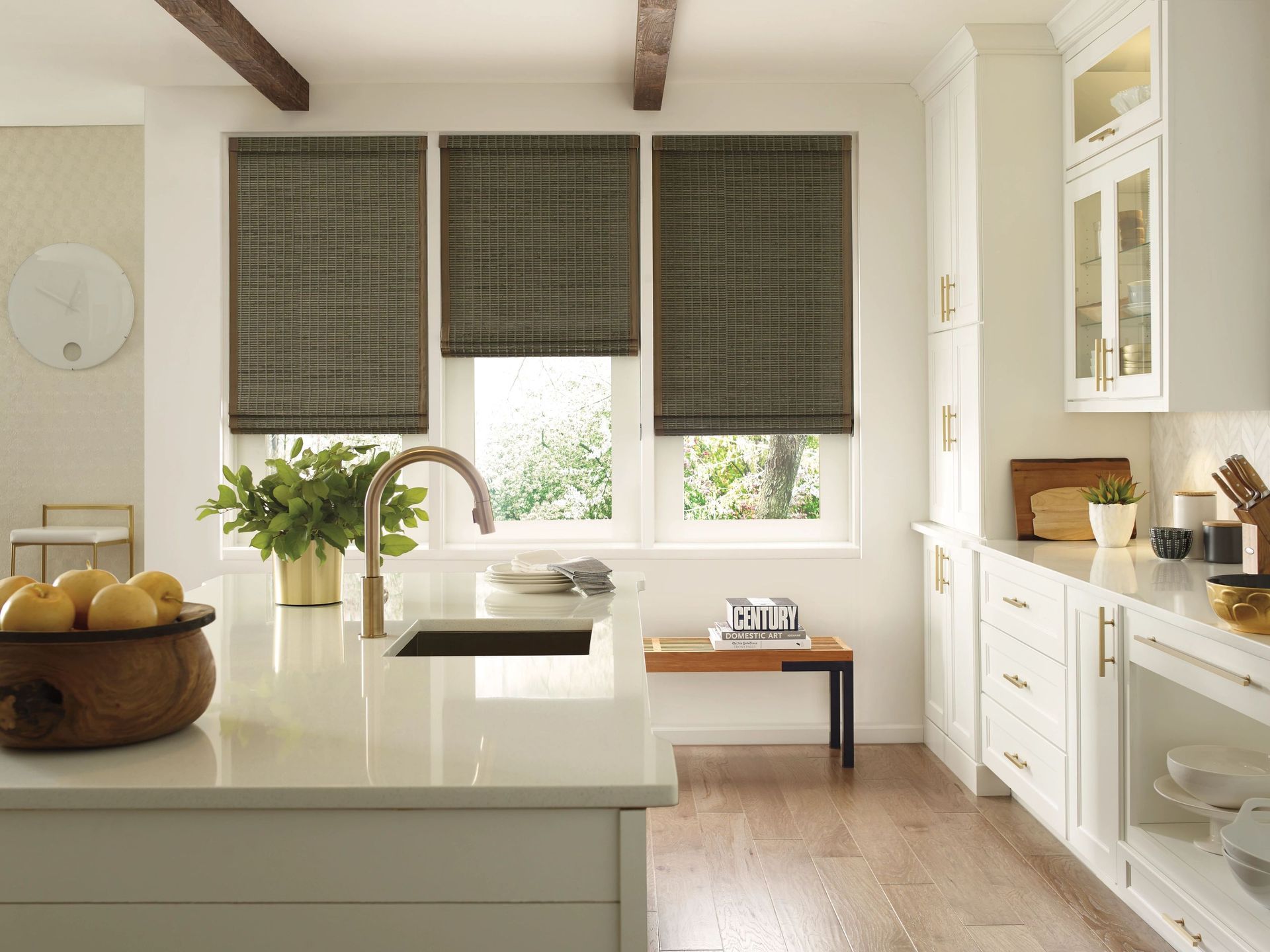 Bright modern kitchen with white cabinets, island, and window blinds over a sink and dining nook