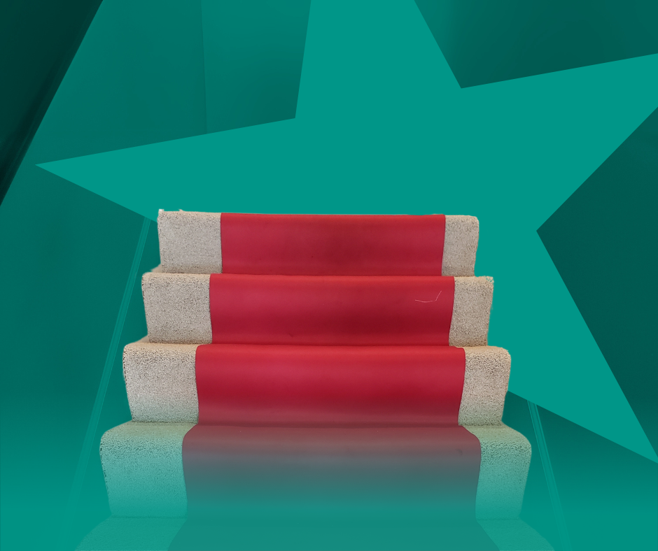 Three-step stage with red carpet, teal star background.