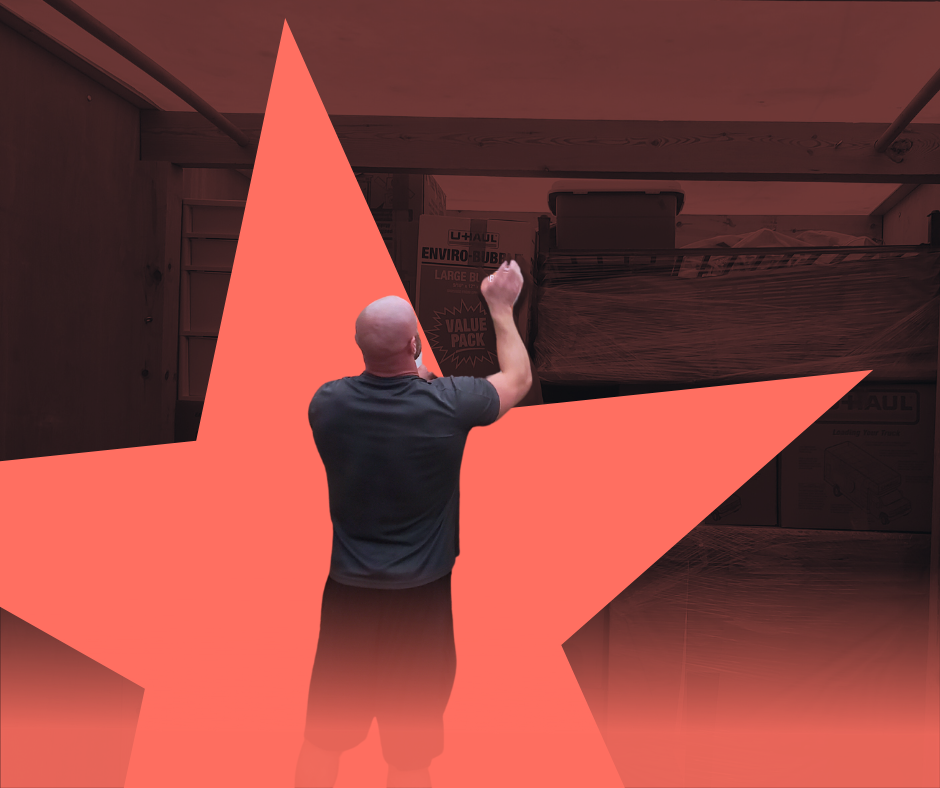 Man in a room, raising arms. Large red star overlay.