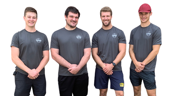 Four men in gray shirts and athletic shorts stand in a row, smiling. One wears a red cap.