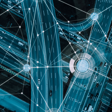 Aerial view of a highway network overlaid with glowing lines and nodes, representing a digital transportation network.