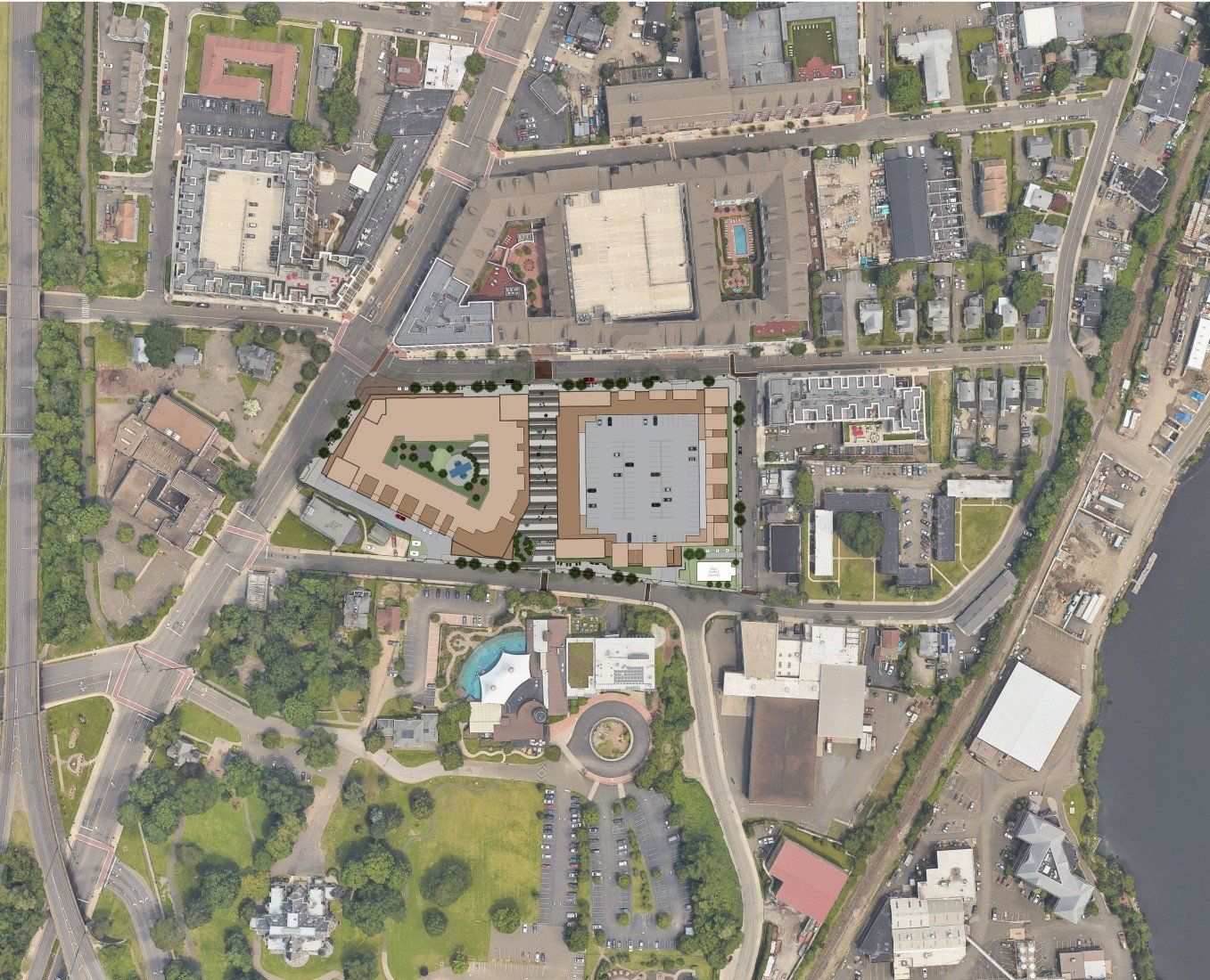 Aerial view of a town center featuring a central rectangular parking lot, surrounding commercial buildings, and greenery.