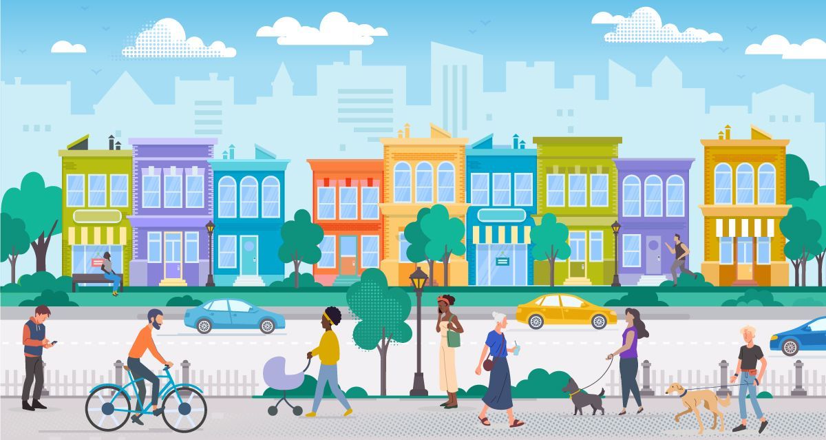 A diverse group of people walk, cycle, and walk dogs along a city sidewalk in front of a row of colorful buildings.
