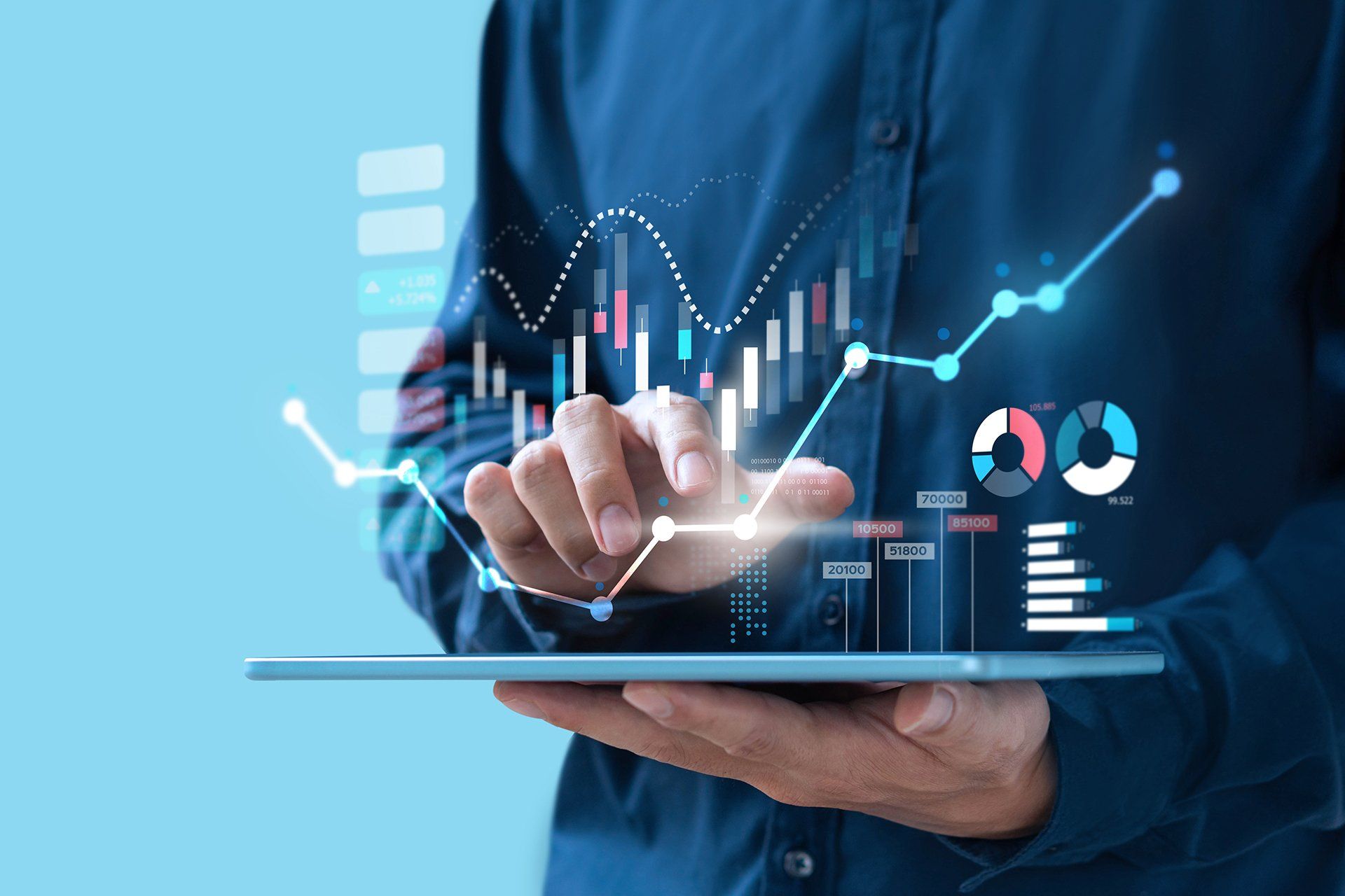 A person in a blue shirt interacts with a glowing, digital financial chart interface floating above a tablet.