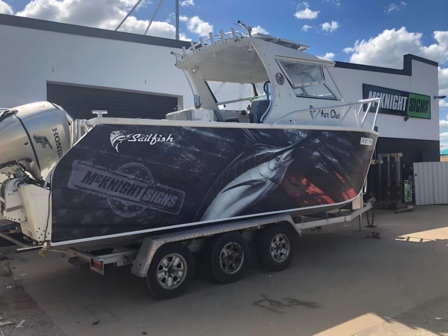 A Boat Is Sitting On A Trailer In Front Of A Building — McKnight Signs In Hillvue, NSW