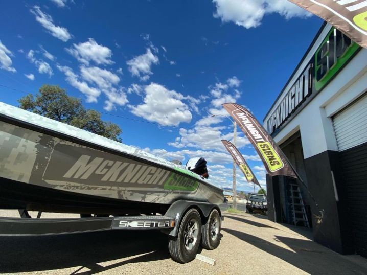 A McKnight Boat Is Parked In Front Of A Building — McKnight Signs In Hillvue, NSW