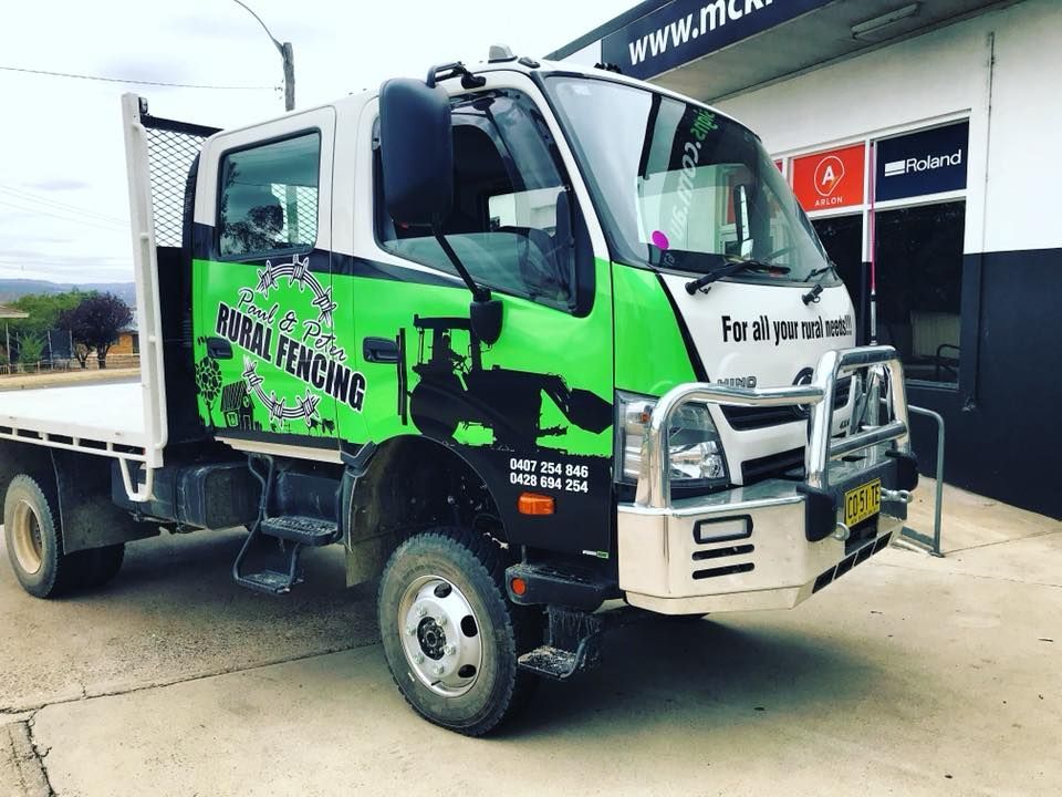 A Green and White Truck is Parked in Front of a Building — McKnight Signs In Armidale, NSW