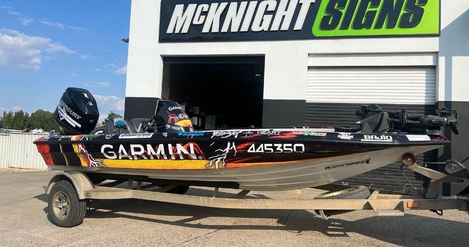 A Boat On A Trailer Is Parked In Front Of A Building — McKnight Signs In Hillvue, NSW