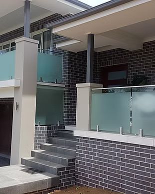 A Brick House With A Glass Railing And Stairs Leading Up To It — McKnight Signs In Hillvue, NSW