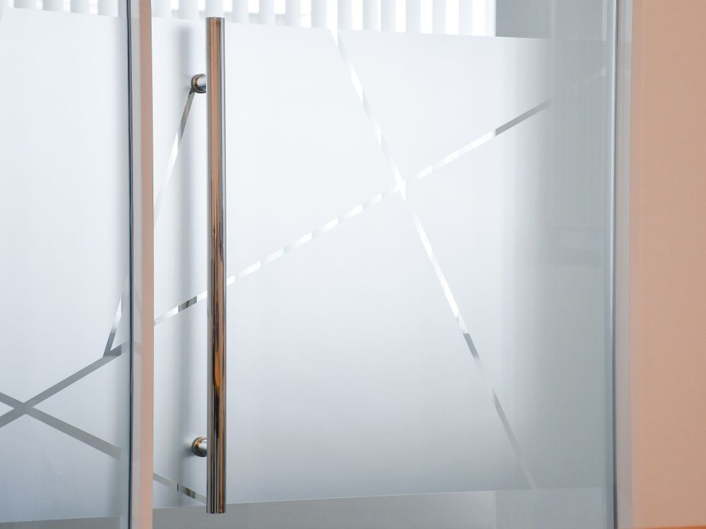 A Close Up Of A Glass Door With A Wooden Handle — McKnight Signs In Hillvue, NSW