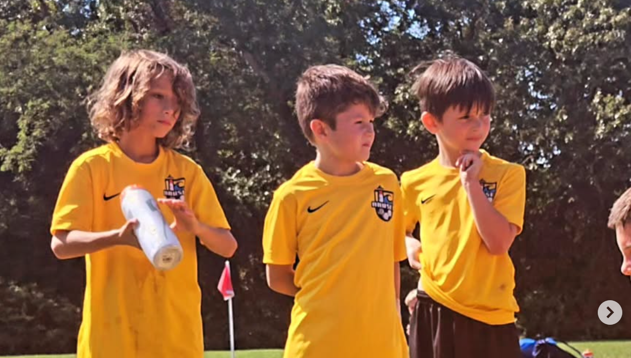 Young AC Boys players listening to coach after the game.