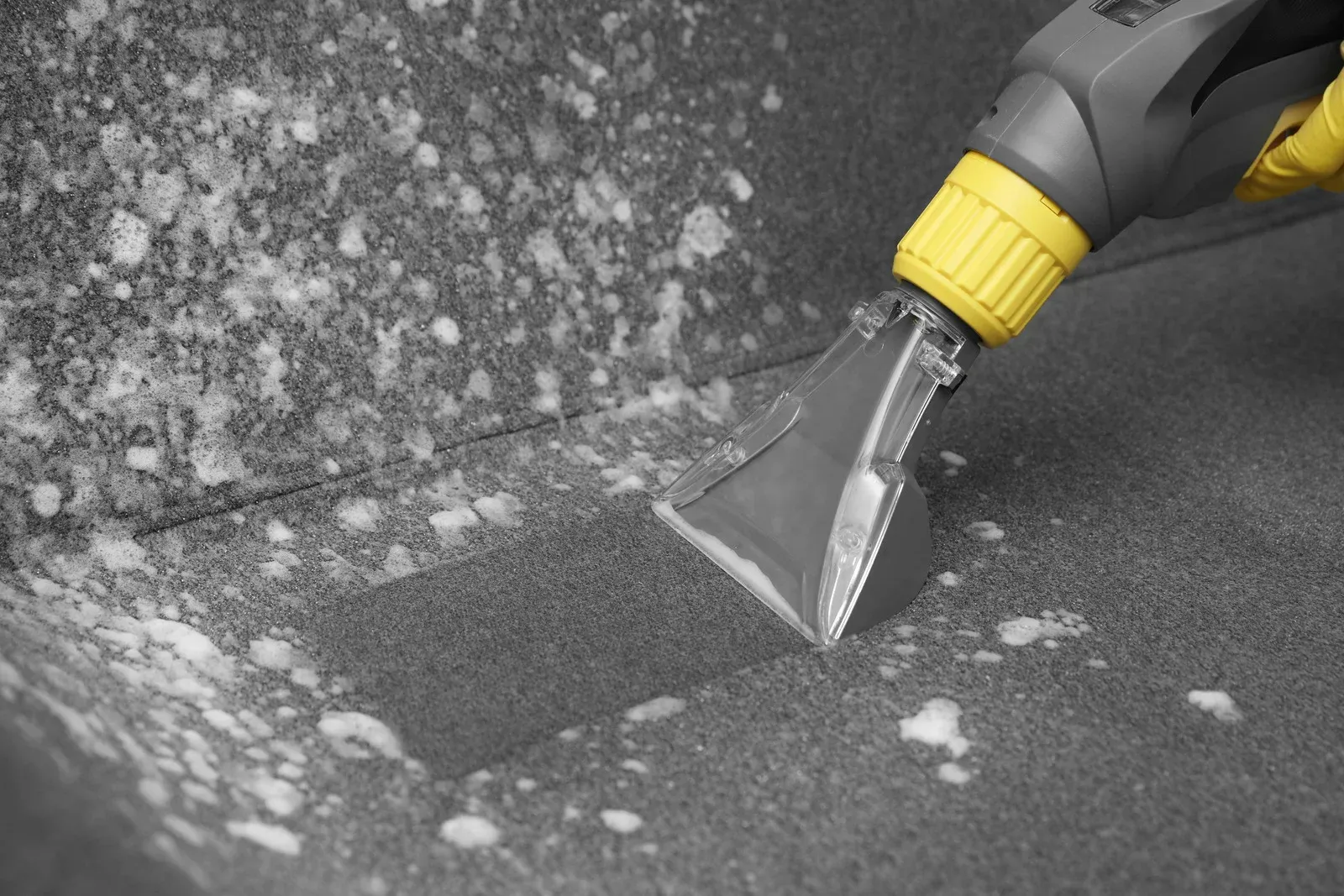 Carpet being cleaned with a yellow and gray upholstery cleaner.