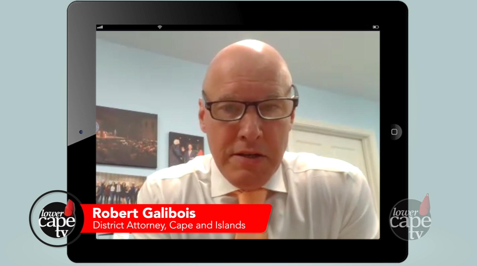 District Attorney Robert Galibois looking into web camera. He is wearing glasses, a white short and 