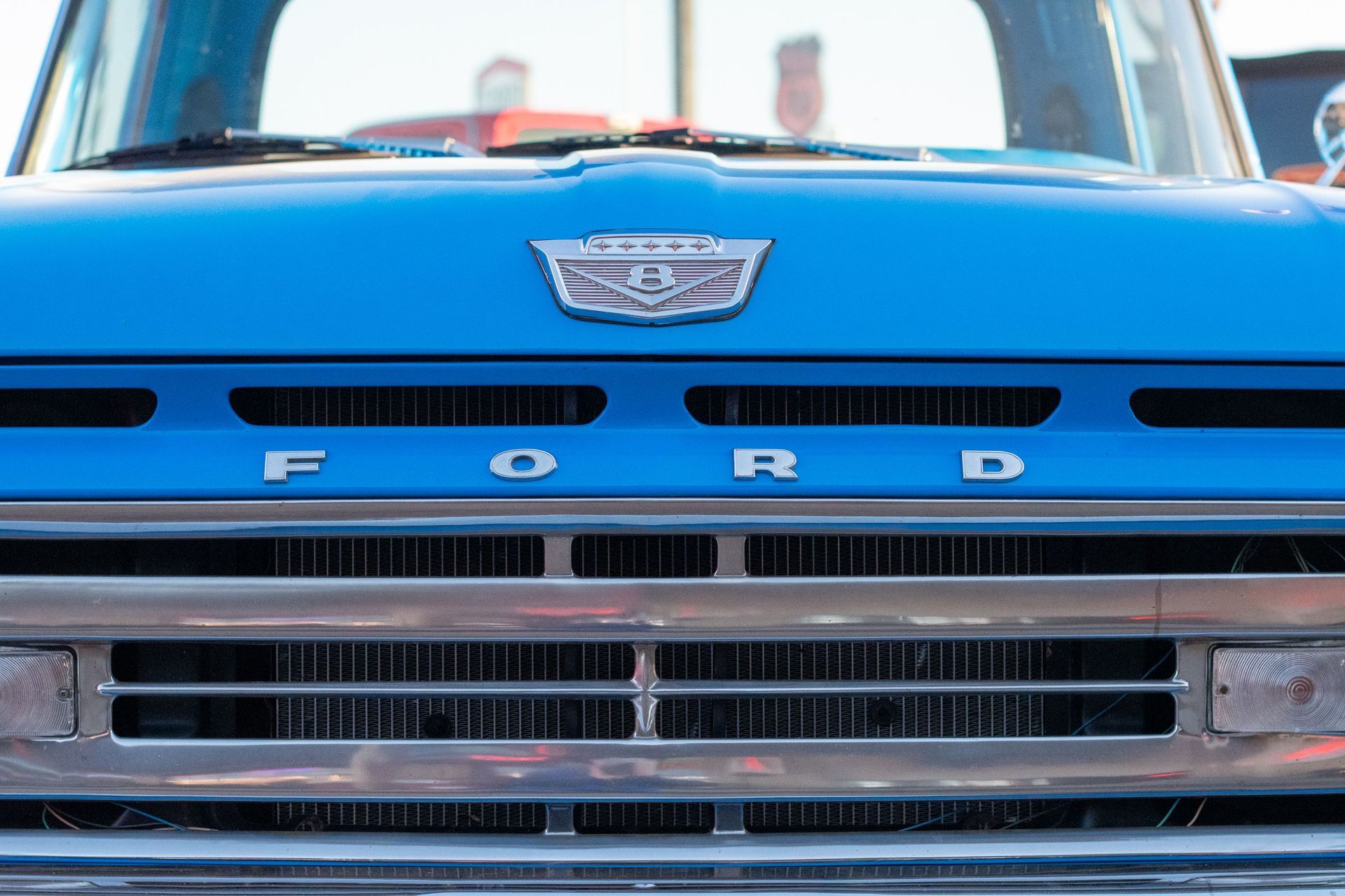 Front view of a blue Ford car grille and emblem