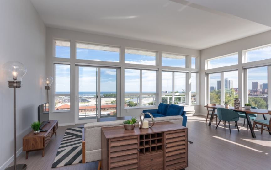 A living room with a lot of windows and a blue couch