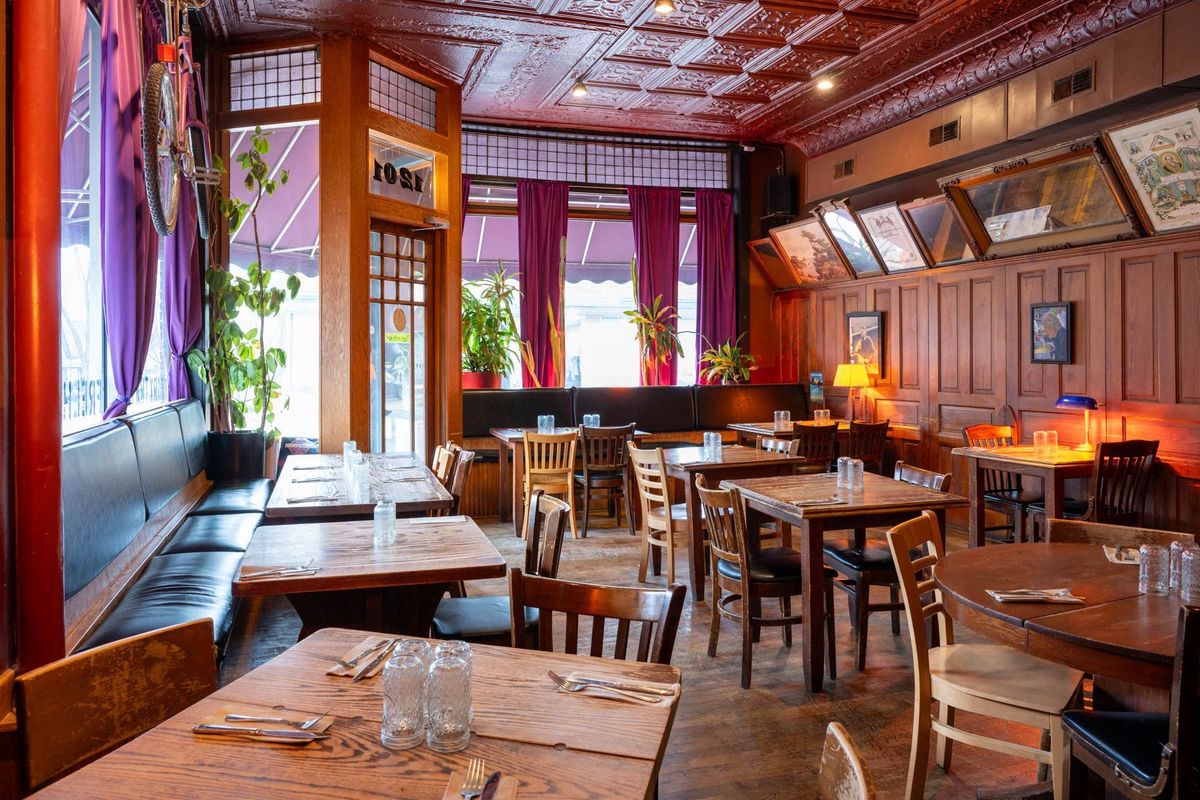 The dining room at The Weary Traveler Freehouse with its tin ceiling, wood paneling and velvet curtains