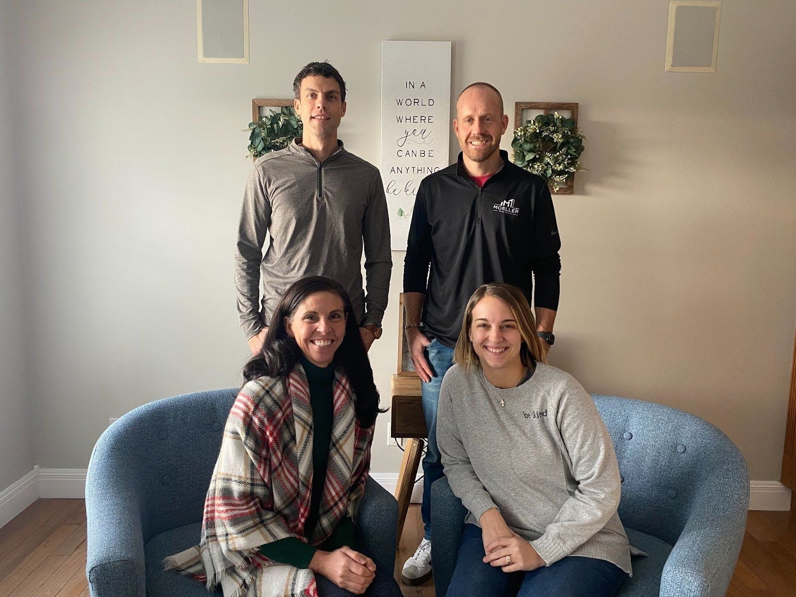 A group of people are posing for a picture in a living room.