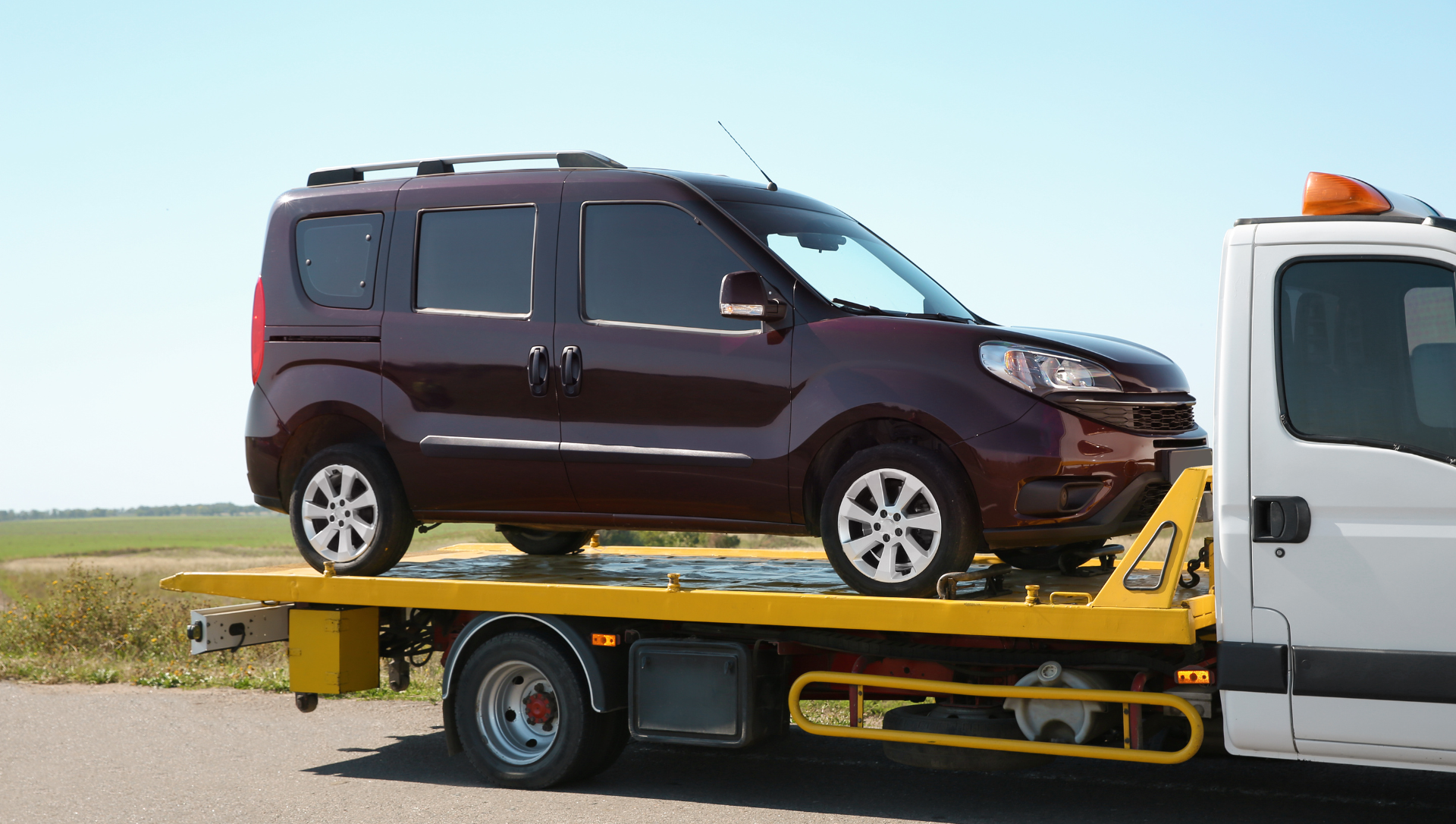 Van secured on a flatbed tow truck on the roadside