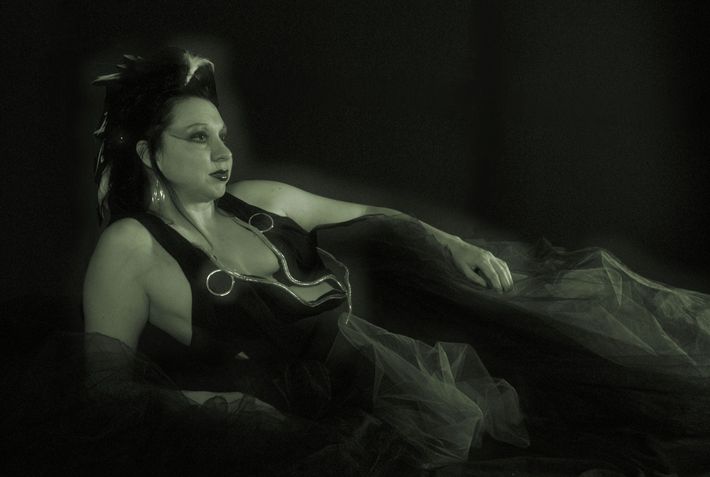 A black and white photo of a woman in a black dress
