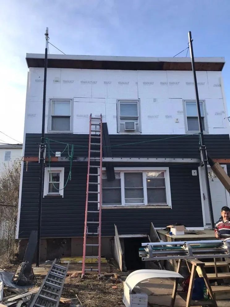 Rowhouse exterior with ladders, scaffolding, and construction materials in front