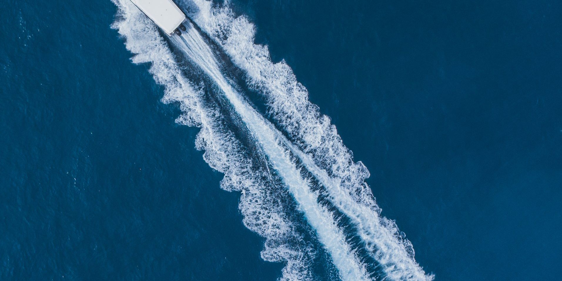 Photo of boat wake from an overhead drone shot of a boat tour.