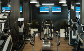 Una donna è in piedi in palestra con le mani sui fianchi.