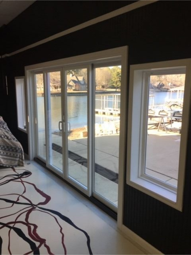 Modern room with sliding glass doors and a window overlooking a waterfront dock.
