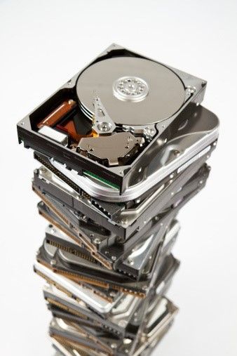 A pile of hard drives are stacked on top of each other.