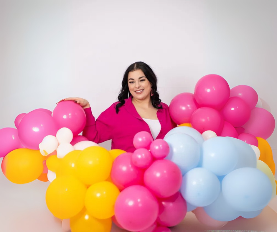 Een tros roze en witte ballonnen hangt aan een touwtje.