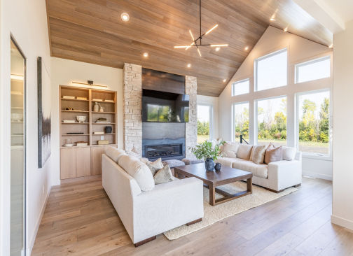 A vaulted wood ceiling, architectural fireplace and expansive windows define the great room. 