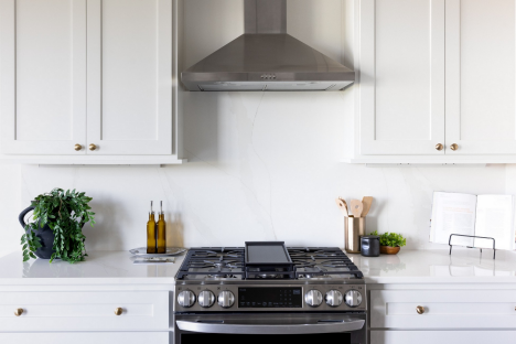 A quiet quartz backsplash allows the range wall to feel clean and uninterrupted.