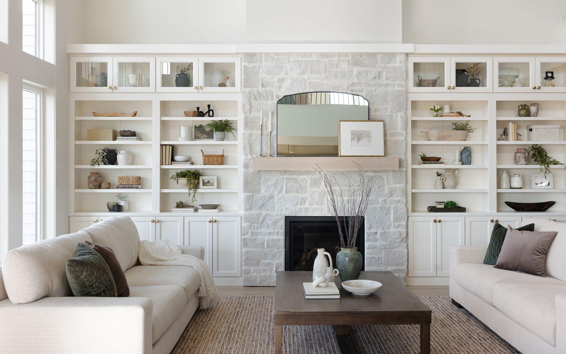 Elegant kitchen with light-colored cabinets, white countertops, and wood ceiling. 