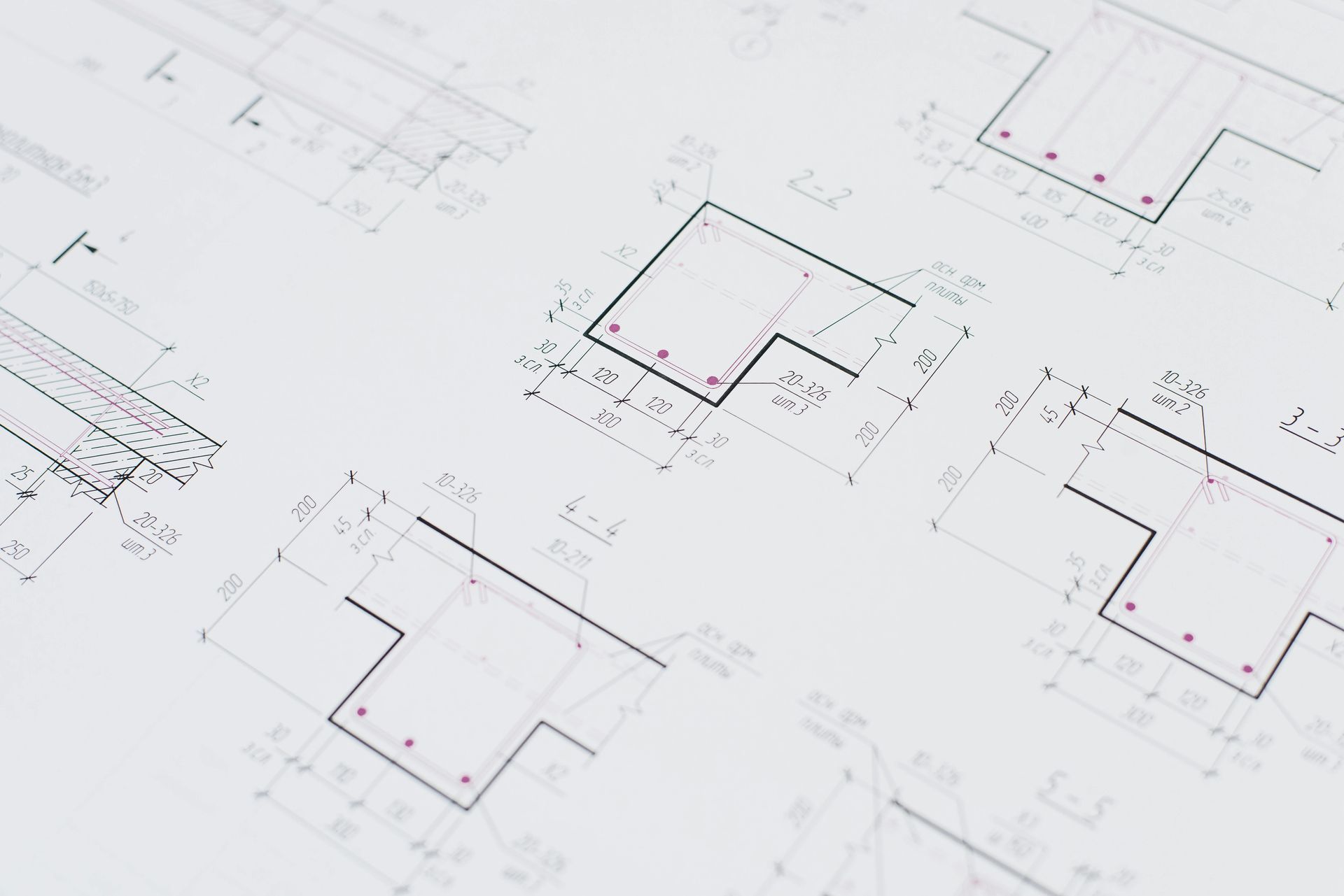 Architectural blueprints with geometric shapes, lines, and numerical annotations, likely for a building's construction.