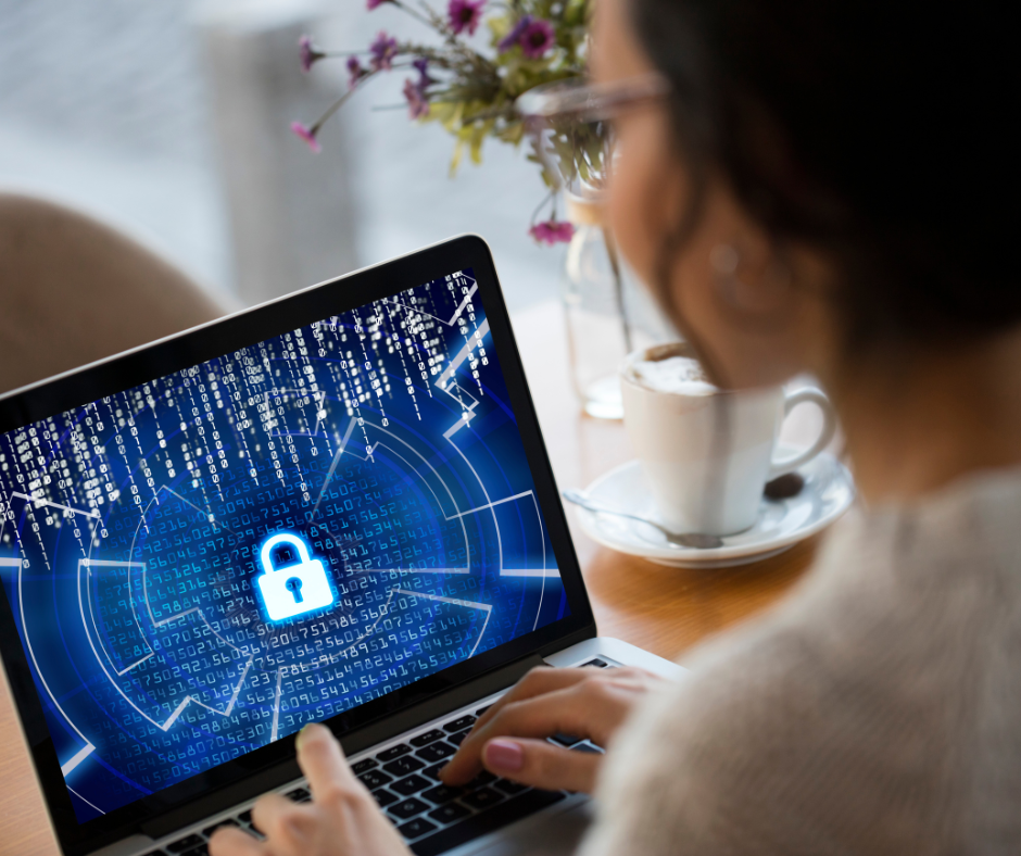 Woman using laptop with security lock icon on screen.