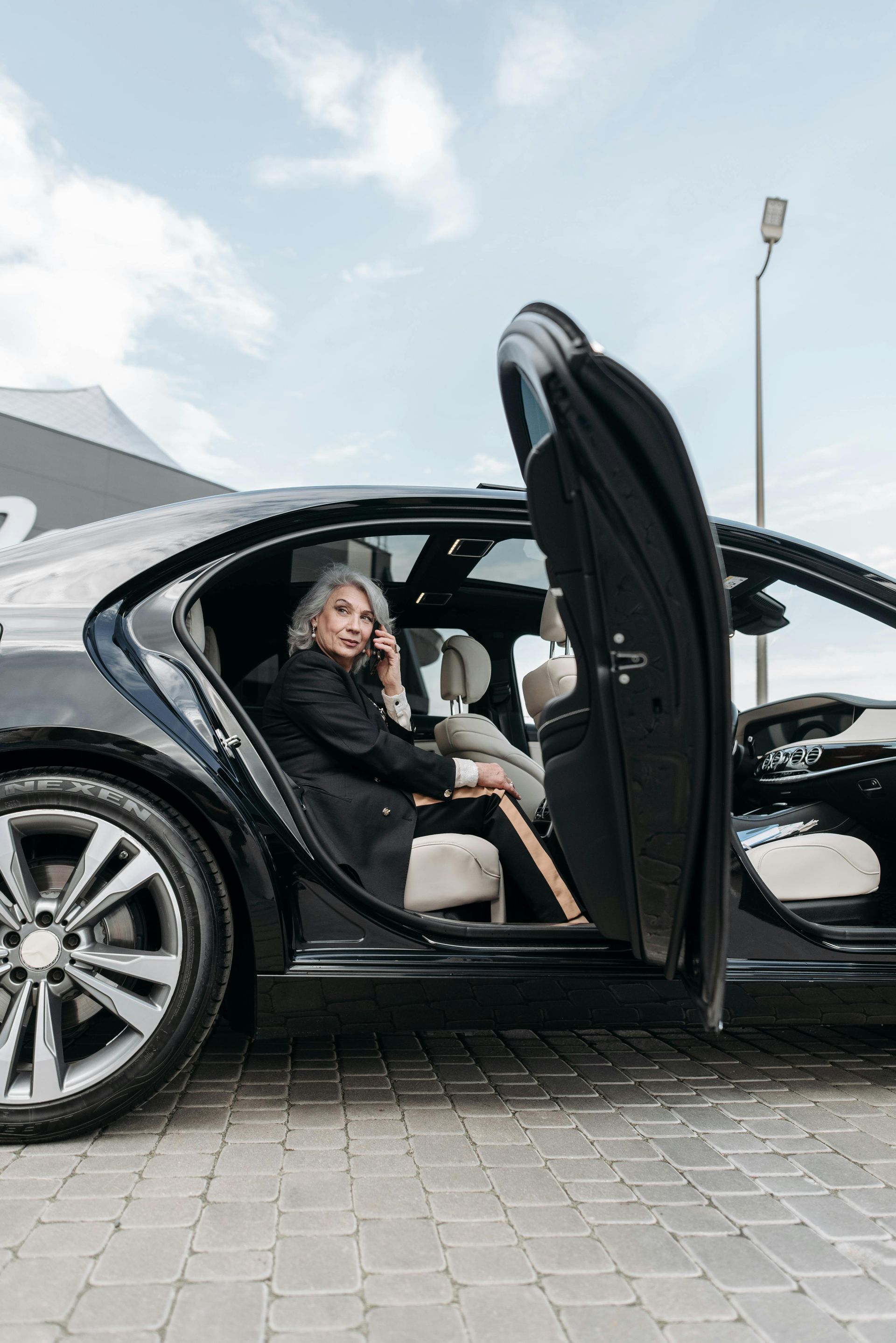 Chauffeur opening luxury car door for professional executive car service passenger