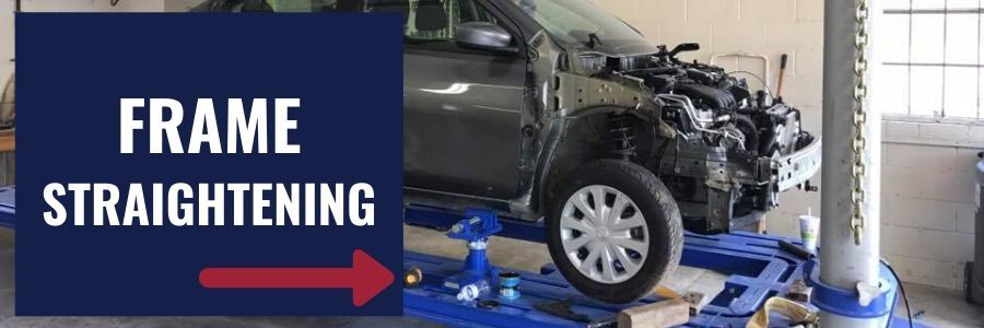 A grey car undergoing frame straightening on a blue automotive lift in a workshop.